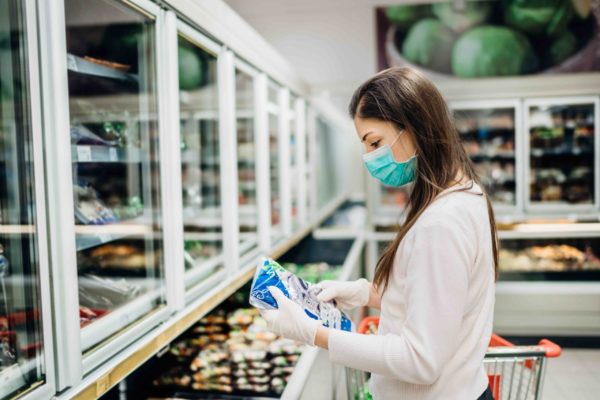 woman shopping with plant based meat packaging